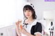 A woman in a maid outfit holding a jar of candy.