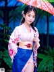 A woman in a kimono holding an umbrella.