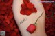 A woman's leg with a rose tattoo on it.