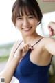 A woman in a blue tank top posing for a picture.