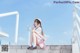 A woman sitting on the steps of a building talking on a cell phone.