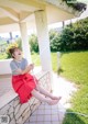 A woman sitting on a bench with a hose in her hand.