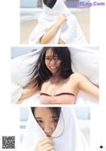A woman wrapped up in a towel on the beach.