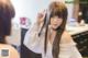 A woman with long brown hair standing in front of a mirror.