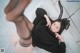 A woman laying on a bed wearing a black sweater and bunny ears.