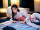 A woman in a white kimono laying on a bed.