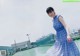 A woman in a blue and white dress standing on a roof.