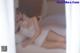A woman in a white lingerie laying on a bed.